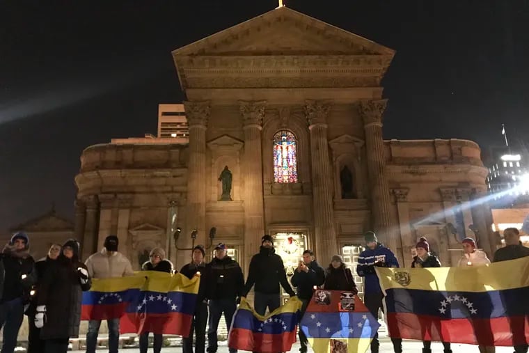 Philly Venezuelans present their flags during a vigil at Sister Cities Park, on Tuesday night.