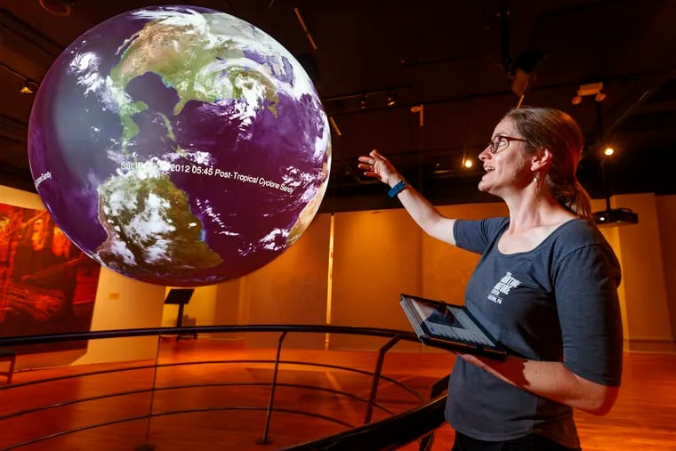 Hurricane Harvey bears down on the United States as Rachel Hogan Carr, who studies people's responses to extreme-weather alerts, tracks its path on an interactive globe at Nurture Nature Center in Easton, Pa.