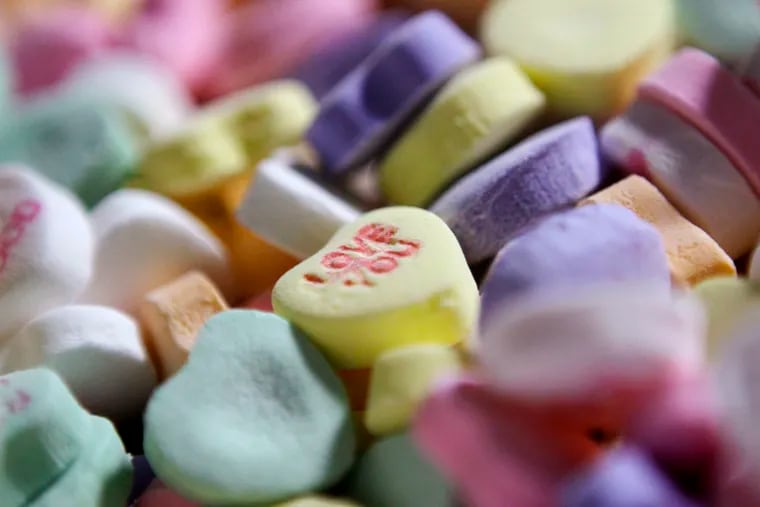 FILE - In this Jan. 14, 2009, file photo, colored Sweethearts candy is held in bulk prior to packaging at the New England Confectionery Company in Revere, Mass. The candies won't be on store shelves this Valentine's Day. The New England Confectionary Co., or Necco, had been making the popular candies since 1886. But the company filed for bankruptcy protection last spring. Ohio-based Spangler Candy Co. bought Necco in May. But Spangler said Thursday, Jan. 24, 2019, that it didn't have time to bring Sweethearts to market this Valentine's season.