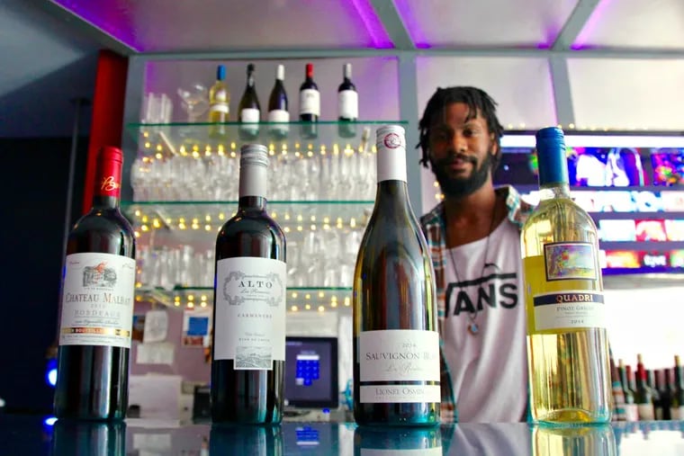 David Dukes, bartender at Jet Wine Bar, with specialty bottles for sale.