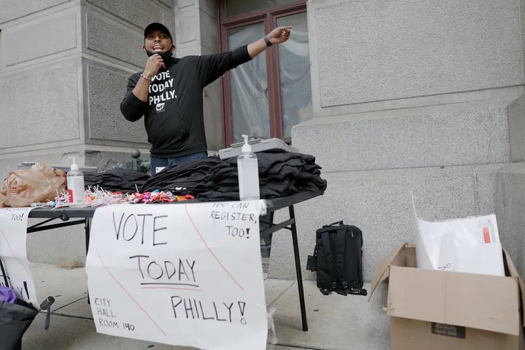 Nicolas O'Rourke, director of organizing for Pennsylvania Working Families, encourages passersby to vote early by casting a mail-in ballot at the satellite election office in Philadelphia's City Hall earlier this month.