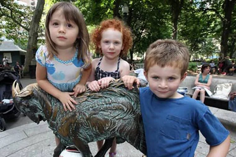 Playing on a goat statue at Rittenhouse Square are (from left) Lucy Shaw, 3; Sonia Borish, 3, and her brother Elijah, 5. They live in Center City with their families. (Steven M. Falk / Staff Photographer)