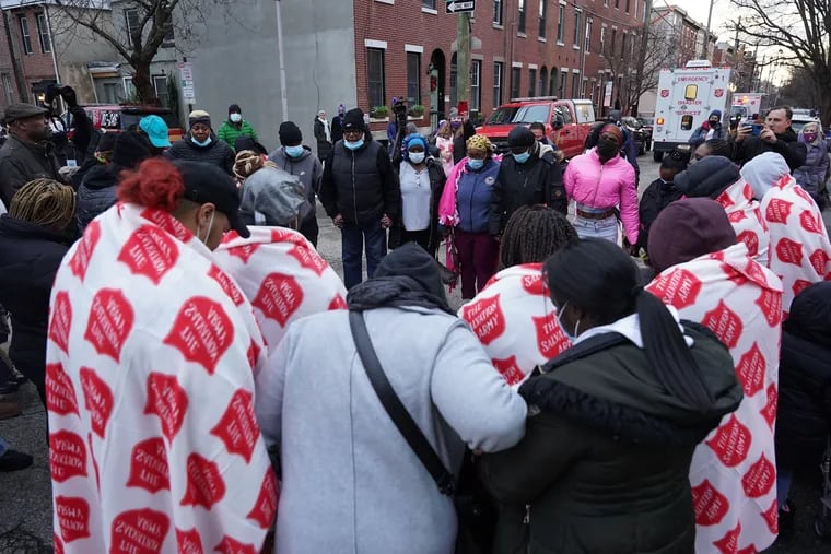Family and friends pray together at the scene of a fatal fire near Parrish and 23rd Street in Fairmount Philadelphia on Wednesday, Jan. 5, 2022. The fire killed 12 people, according to police. (Thomas Hengge/The Philadelphia Inquirer/TNS)