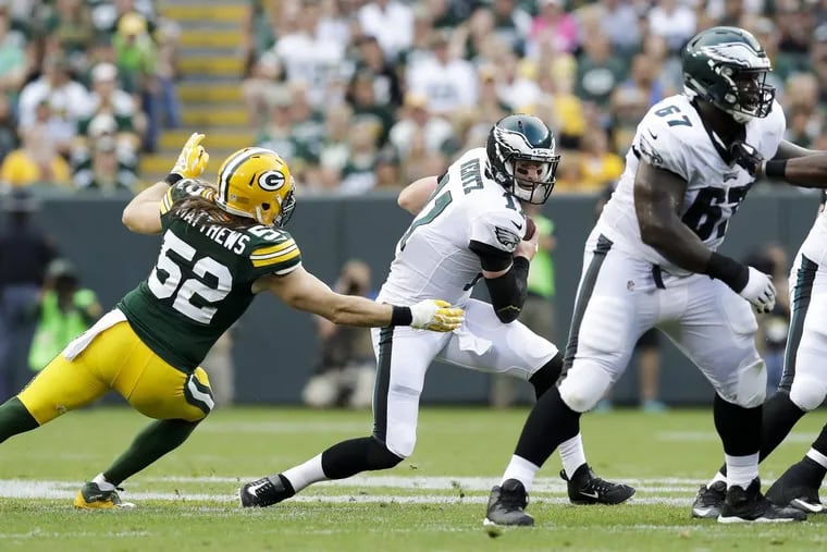 Eagles quarterback Carson Wentz scrambles against Packers outside linebacker Clay Matthews during the first-quarter in a preseason game at Lambeau Field in Green Bay WI on Thursday.