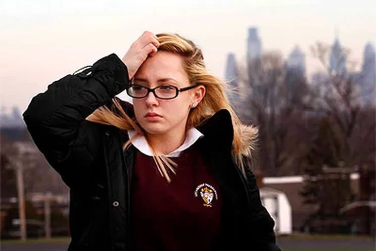 Sara Brown, a sixteen year old sophomore at Archbishop Prendegast High School, reacts on the school campus with the skyline of Philadelphia on the horizon after hearing that her school will be closed on Friday afternoon, Jan. 6, 2012.  (Laurence Kesterson / Staff Photographer)