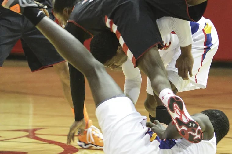 Imhotep's Jakwan Jones dives over Frankford's Bamba Jaye for a loose ball during the 1st quarter.