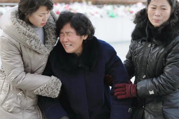In this late Dec. 19, 2011 photo, North Koreans react following news of their leader Kim Jong Il's death after 17 years in power, at Mansudae Hill in Pyongyang, North Korea. North Koreans marched by the thousands Monday to their capital's landmarks to mourn Kim Jong Il, many crying uncontrollably and flailing their arms in grief over the death of their "Dear Leader." (AP Photo/Kyodo News) JAPAN OUT, MANDATORY CREDIT, NO LICENSING IN CHINA, FRANCE, HONG KONG, JAPAN AND SOUTH KOREA