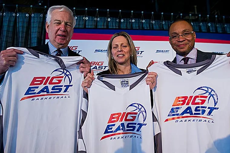 From left, basketball commentator Bill Raftery, Big East Commissioner Val Ackerman, and basketball commentator Gus Johnson hold jerseys. (Craig Ruttle/AP)