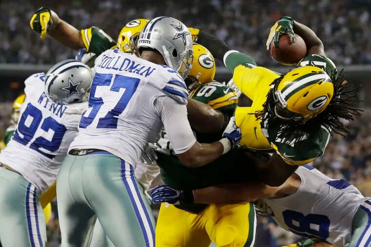Dreadlocks flying, Packers running back Eddie Lacy (27) goes over the top to score the winning TD against the Cowboys. Green Bay had two interceptions in the final three minutes.