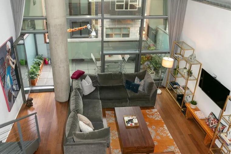 The 1,537-square-foot unit features a two-story living room with floor-to-ceiling windows.