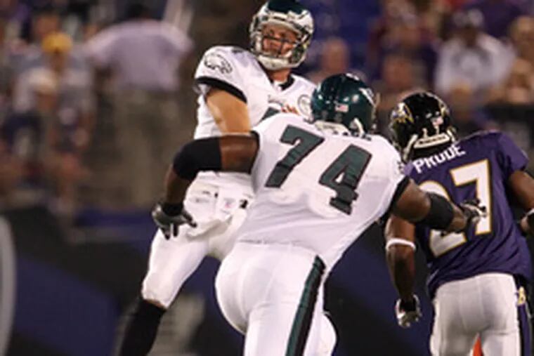 Eagles' Kevin Kolb fires pass with Winston Justice trying to block rushing Raven Ronnie Prude.