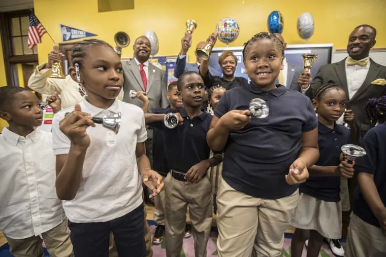 Saiyan Stewart (from left), Kahreem Braboy, and Sanaya Meade, all 7, ring in the new school year in the classroom of Lisa Johnson at Pennell Elementary School on Tuesday,  along with City of Philadelphia officials.