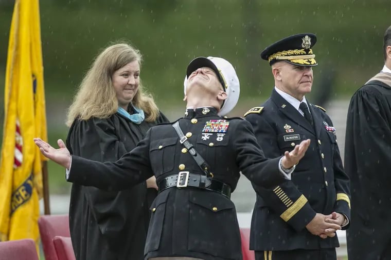 Valley Forge Military Academy held its 2017 commencement Saturday morning under cloudy sky which at times turned into a drenching rain.  Here, Col.l John C,. Church opens his arms and looks to the sky during a downpour near the end of the commencement ceremony. Standing with Church are Megan Sukkivan, Director of Guidance, and General H.R. McMaster, National Security Adviser.