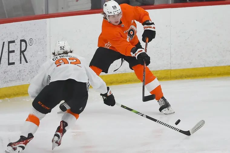 Flyers defenseman Oliver Bonk (right) passes the puck earlier this month at development camp.