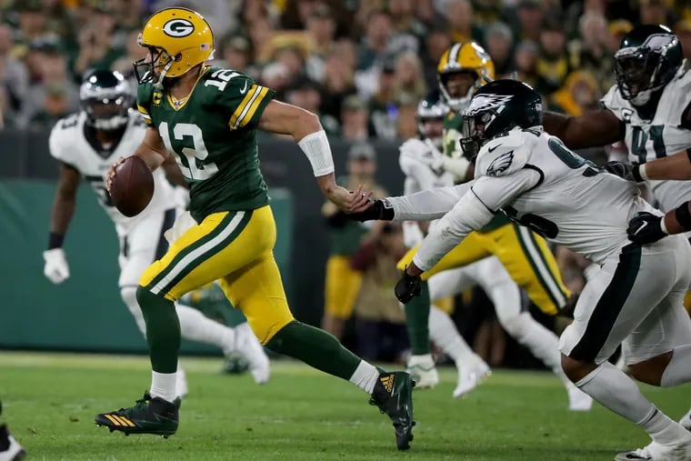 Green Bay Packers quarterback Aaron Rodgers avoids a tackle by the Eagles' Derek Barnett, who later made the game-changing play with a strip-sack of Rodgers.