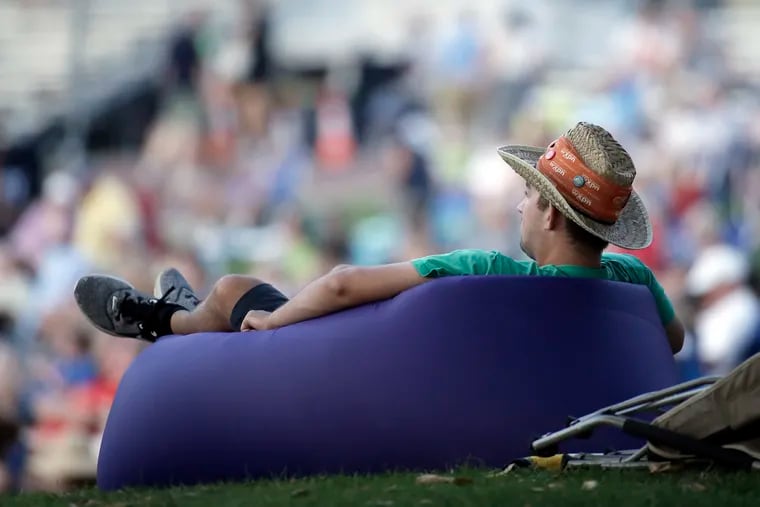 Quinn Meadowcroft of Philadelphia relaxes on his inflatable air couch, closing out three days of music at the XPoNential Music Festival at Camden’s Wiggins Park in 2019.