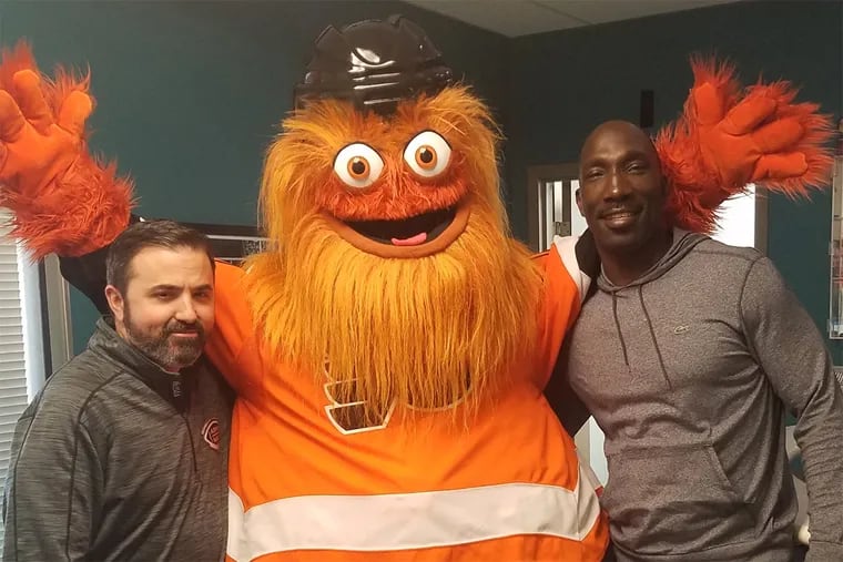 WIP afternoon hosts Jon Marks (left) and Ike Reese pose with Gritty at the station's Center City studio.