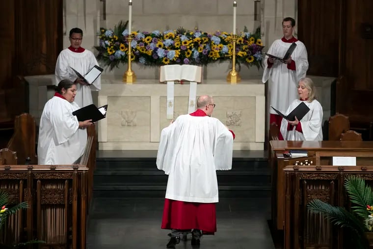 Andrew Senn (center) conducts a small number of singers from the choir inside the First Presbyterian Church in Philadelphia on Friday. They pre-recorded music for Sunday's online church service.