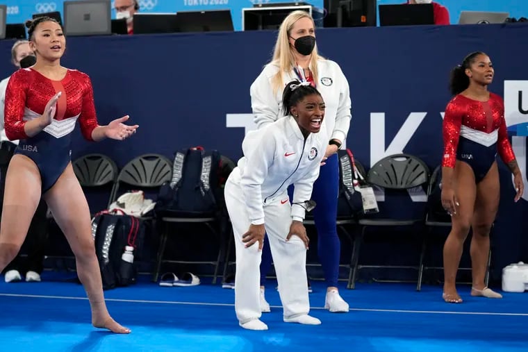 Gymnasts from the United States, Simone Biles, centre, Jordan Chiles , right, and Sunisa Lee cheer the performance of teammate Grace McCallum performs on the floor during the artistic gymnastics women's final at the 2020 Summer Olympics, Tuesday, July 27, 2021, in Tokyo.