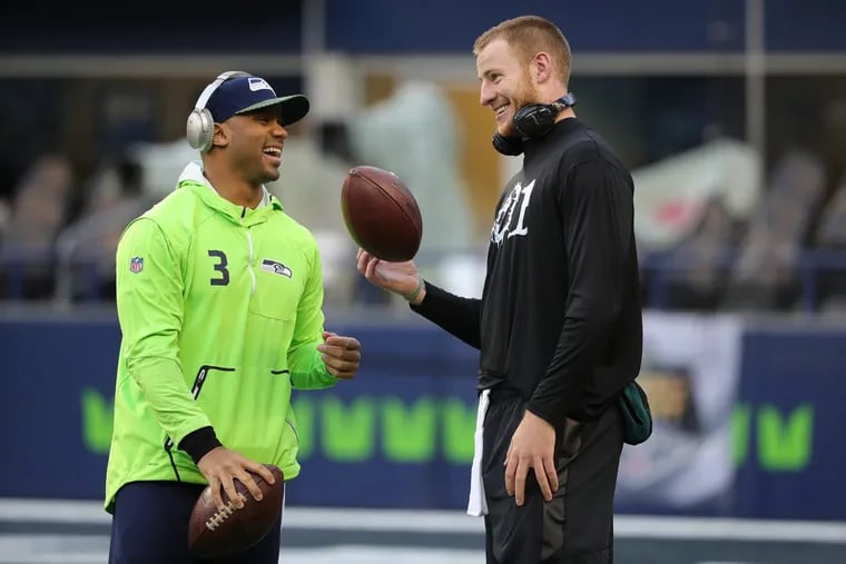 Seahawks’ Russell Wilson, left, and Eagles’ Carson Wentz, right, talk as they warm up before the Philadelphia Eagles play the Seattle Seahawks in Seattle, WA on December 3, 2017.