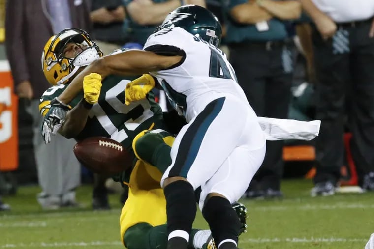 Green Bay’s Malachi Dupre loses the ball as he is hit by Eagles safety Tre Sullivan on Thursday night.