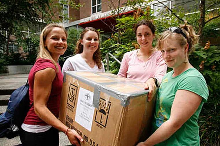 Penn nursing students (from left) Megan VanBuskirk, Blair Kraus, Megan Turnbill and Lydia Warner carry a box filled with medical supplies they are taking to Botswana. (Alejandro A. Alvarez / Staff )