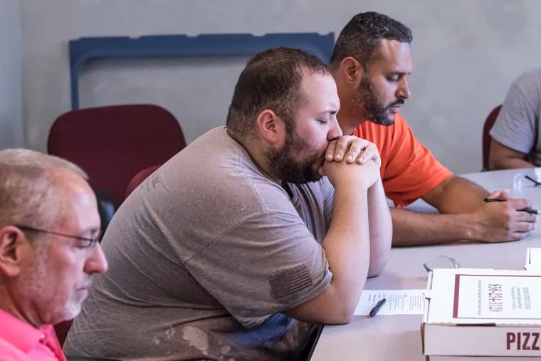 From left, David Carosiello, operations manager, Joey Torres, lead painter, and Joshua Ramos, supervisor, pray during a staff meeting at Productive Plastics in Mount Laurel, New Jersey. Thursday, August 2, 2018. Productive Plastics is a plastic fabrication company that brings in two faith-based motivational speakers once a month to speak with its employees.