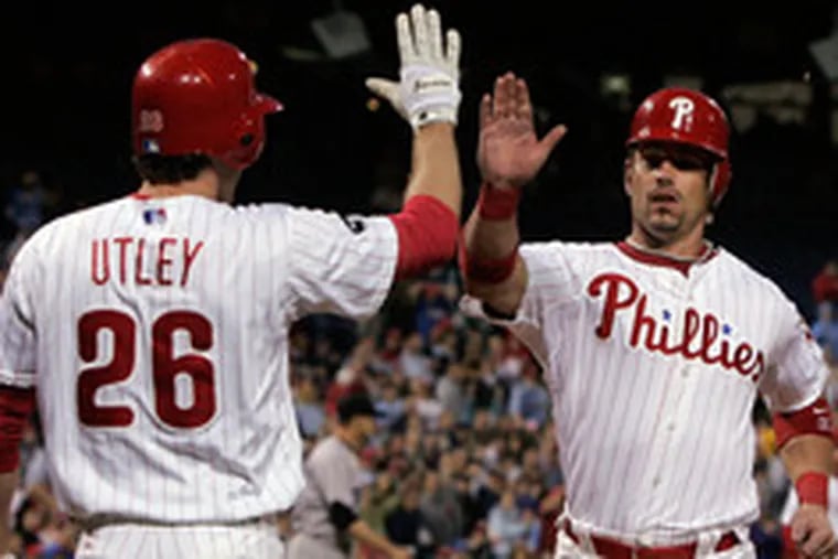 Aaron Rowand accepts congratulations from Chase Utley as he scores on a sacrifice fly by Jimmy Rollins in the Phillies&#0039; five-run fifth.