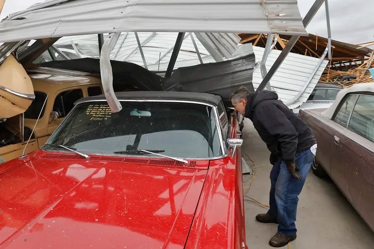 Russ Noel, owner of Country Classic Cars, looks at one of the damaged cars, Sunday, Dec. 2, 2018, at Country Classic Cars near Staunton, Ill. A suspected tornado ripped through the business destroying two buildings and damaging more than 100 cars. (J.B. Forbes/St. Louis Post-Dispatch via AP)