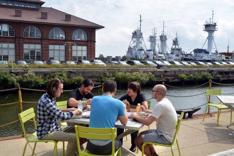 At the Navy Yard in South Philadelphia, a group of employees enjoys lunch outside of Building 543. The location is being highlighted as a potential location for Amazon’s corporate headquarters.