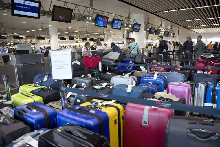 Passengers check in among left pieces of luggage at Brussels Zaventem Airport in Brussels on Thursday, June 15, 2017. A power outage delayed departing planes.
