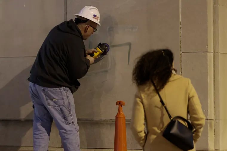 A spray-painted swastika is removed from a wall adjacent to the Horwitz-Wasserman Holocaust Memorial Plaza on the Ben Franklin Parkway in January. In the latest act of antisemitic vandalism, a swastika was painted on a sign Saturday night at Temple Beth Hillel-Beth El in Wynnewood.