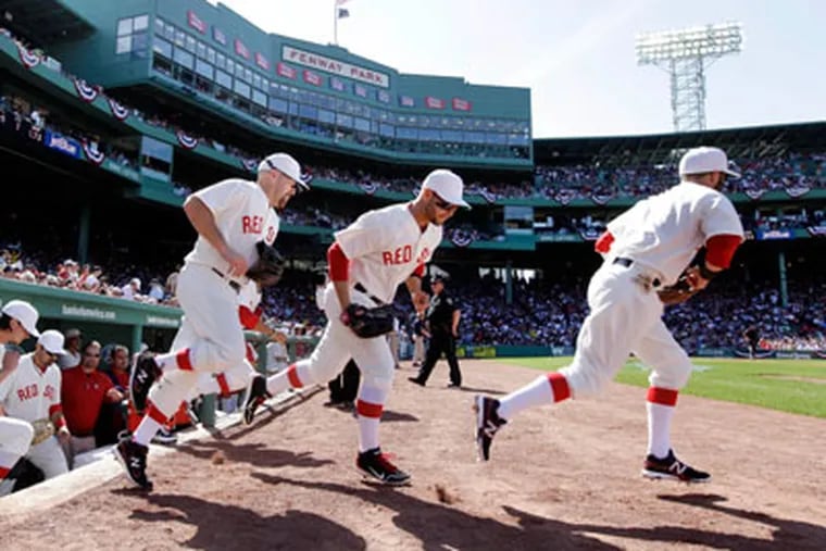 Red Sox players take the field in throwback uniforms to celebrate the 100th anniversary of Fenway Park's first game. (Elise Amendola/AP)