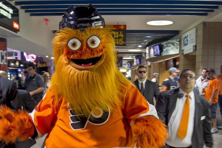Gritty, the Philadelphia Flyers' new mascot, travels with his "security detail" through the crowd during a game at the team's home opener at the Wells Fargo Center on Oct. 9, 2018. (Tom Gralish/Philadelphia Inquirer/TNS)