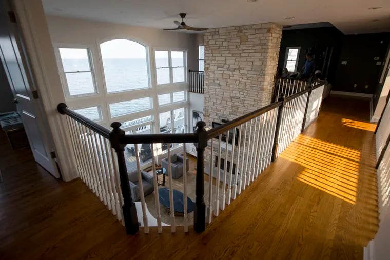 The house has 20-foot floor-to-ceiling views of the water, plus a two-story fireplace.