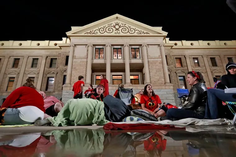 Teachers camp out for the night as the Arizona legislature debates a budget negotiated by majority Republicans and GOP Gov. Doug Ducey at the Capitol in Phoenix on May 3, 2018. Attempts that year to boost school funding by raising taxes on the wealthy stalled, but the state voted in such a tax in November.