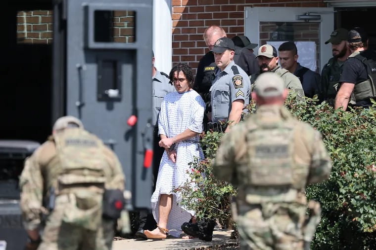 Danilo Cavalcante, seen being walked from the Pennsylvania State Police barracks in Avondale on Wednesday, survived for two weeks on watermelon, creek water, and stealth.