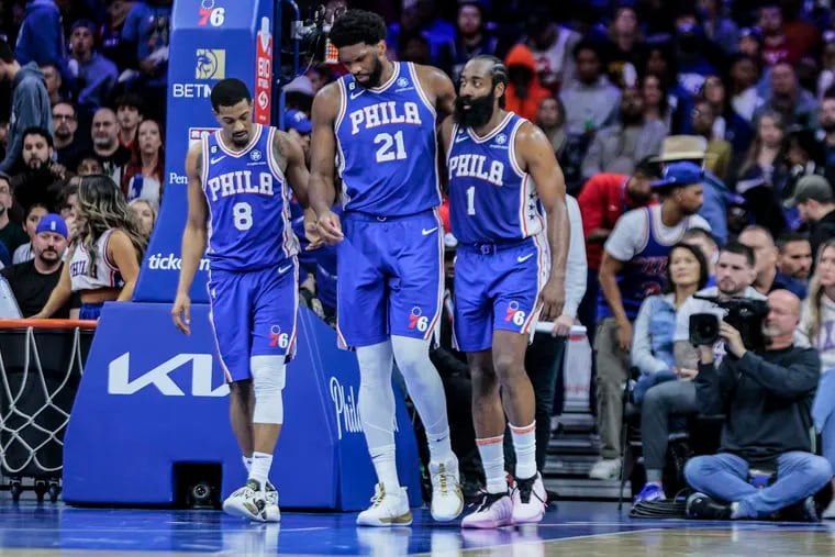 Sixers center Joel Embiid his helped off the court by De’Anthony Melton (left) and James Harden after he was hurt in the game against the Pelicans on Monday.