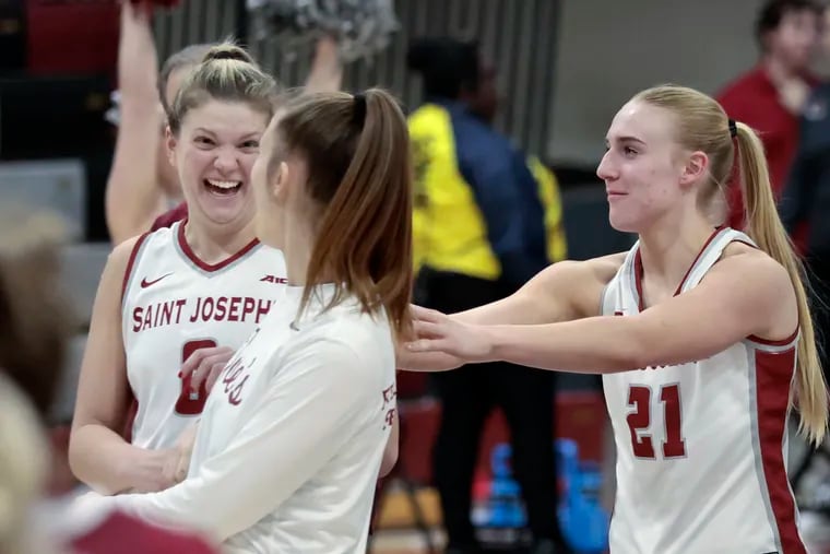 St. Joe’s junior Talya Brugler (left) celebrates with teammates, including Mackenzie Smith (right), after a win earlier this season. Brugler and Smith have been key to the Hawks' resurgence this season.