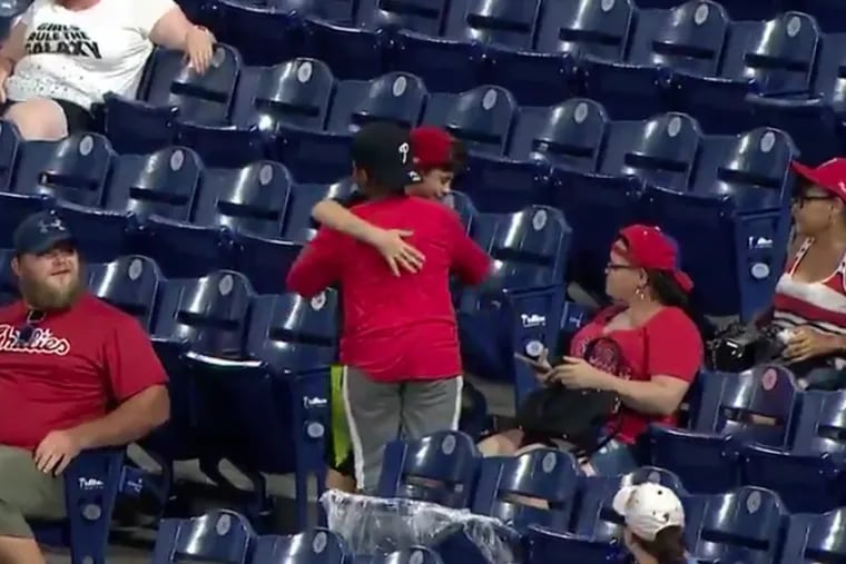 One young Phillies fans thanks another after being given a foul ball during Wednesday night's rain-delayed loss to the Los Angeles Dodgers.
