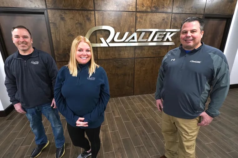 Mike Williams, chief busines officer, Liz Downey, chief administrative officer, and Scott Hisey, founder and CEO of QualTek, in the company's lobby in Blue Bell.
