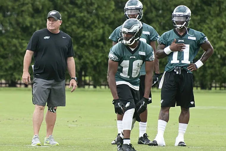Chip Kelly works with the wide receivers. (Ron Tarver/Staff Photographer)