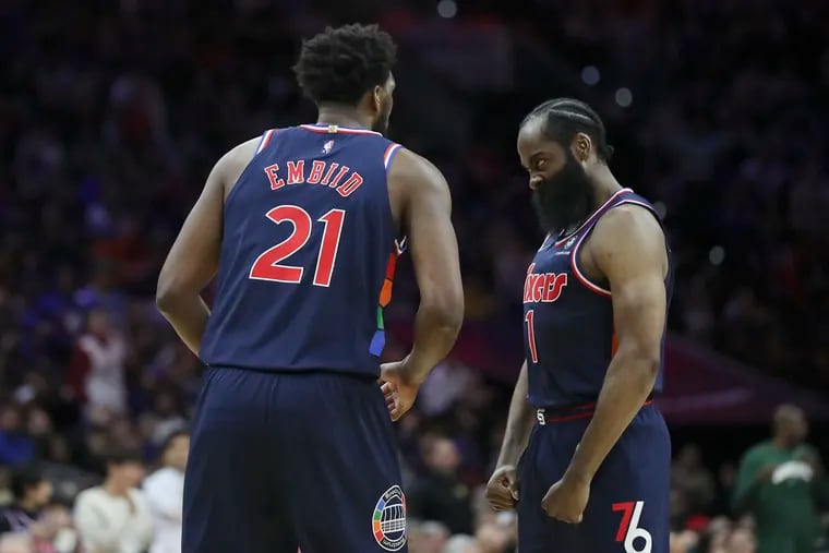 Sixers guard James Harden (1) celebrating with center Joel Embiid (21) after Embiid made a basket and drew a foul on Brook Lopez of the Milwaukee Bucks in the fourth quarter of a game at the Wells Fargo Center in Philadelphia on March 29.