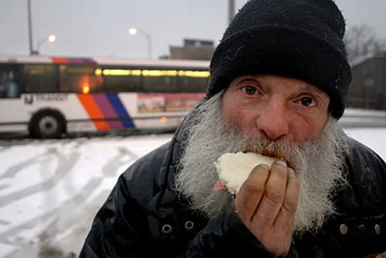 John Palumbo, 53, eats a baloney sandwich VOA outreach workers gave him after he completed an interview near where he lives in a homeless tent city.  ( Tom Gralish / Staff Photographer )