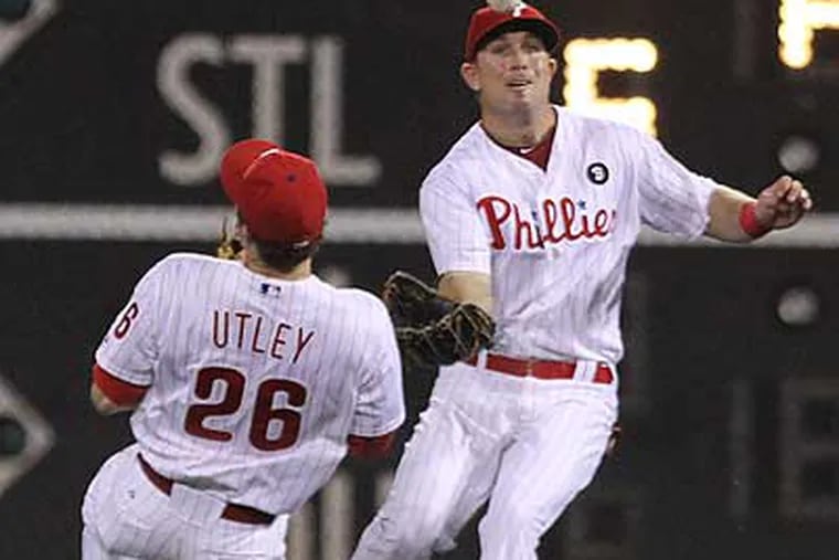 John Bowker, right, and Chase Utley can't come up with a flyball that dropped in right field. (Michael Bryant/Staff Photographer)