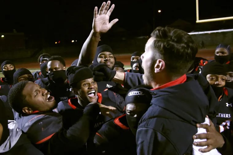 Imhotep players celebrate with coach Nick Lincoln (right) after winning the Public League Class 4A football championship.