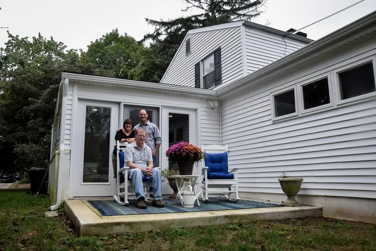 Bobbi (left) and Mark Helms (sitting) recently renovated their Lafayette Hill home to accommodate Mark's difficulty walking which stems from his diagnosis with Parkinson's Disease with the help of contractor Jon Domer (right). Here, they are outside of the sunroom which was apart of the renovation.