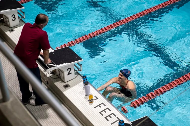 Penn swimmer Lia Thomas speaks with her coach during her warm up with her team before the Women’s Swimming and Diving meet against Harvard Crimson’s at the Blodgett Pool at Harvard University in Boston, Mass., on Saturday, Jan. 22, 2022.