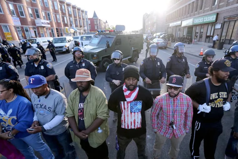 Baltimore police and protesters in a calm moment Tuesday at West North and Pennsylvania avenues. (DAVID SWANSON / STAFF PHOTOGRAPHER)