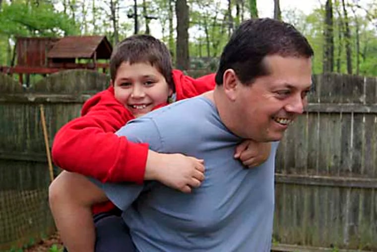 Stuart Chaifetz plays with his autistic son Akian Chaifetz, 10, in the backyard of their home in Cherry Hill, N.J., earlier this week. (AP Photo/Mel Evans)